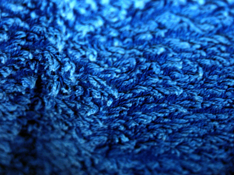 Blue knitted fabric as a background. Close-up image.