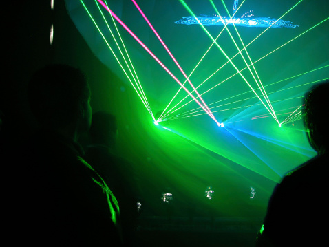 Silhouettes of people attending a laser show with beautiful greeny background. This is part of series! Check my portfolio. Please send usages and feedback, thanks.