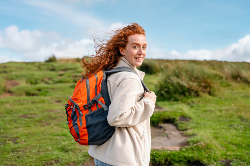 amazed Woman in jacket reaching the destination and taking selfie and shouting on the top of mountain at sunset. Travel Lifestyle concept The national park Peak District in England