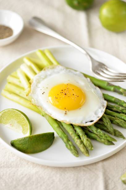 istock Boiled asparagus with fried egg and black pepper. Healthy breakfast 1721393954