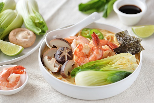 Asian soup with noodles, shiitake mushrooms, shrimp tails, bok choy, hot peppers and nori