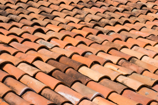 Subject: Horizontal view of a well-aged red ceramic tile roof in the bright sunlight of Mexico