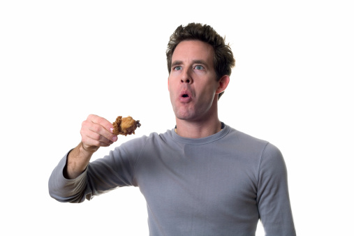 man surprised at how delicious that piece of chicken is