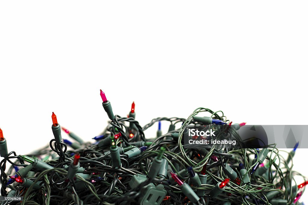 Pile of Tangled Christmas Lights on White Background High key photo of numerous strands of Christmas lights that need to be untangled.  Anyone  :) Tangled Stock Photo
