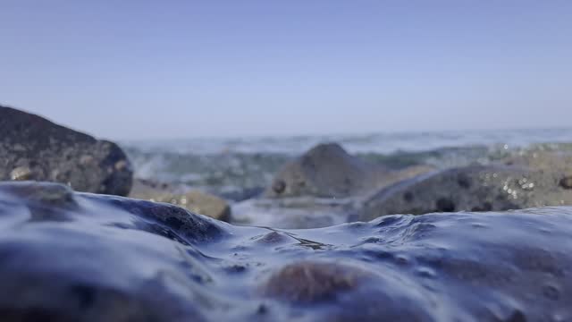 Waves beating rocks and stones of beach 4k stock video