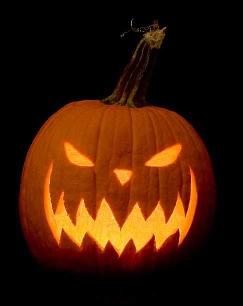 A Halloween jack-o-lantern made of pumpkin A scary Jack-O-Lantern lit up on a black background. halloween pumpkin jack o lantern horror stock pictures, royalty-free photos & images