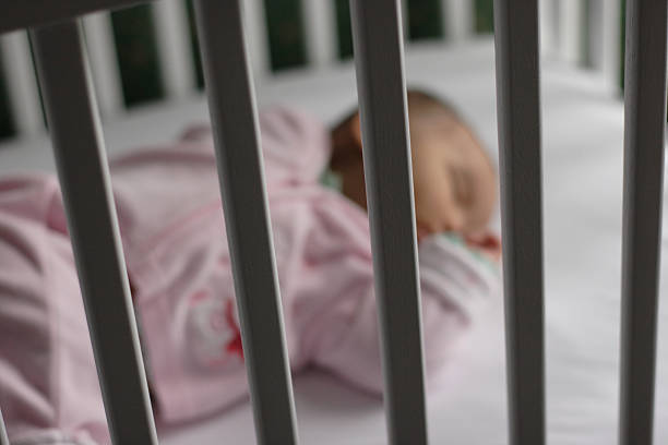 Baby Safely Asleep in Crib stock photo
