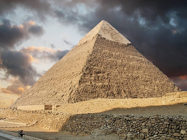 Photo of a pyramid in Giza showing stormy clouds above Giza Pyramids in Egypt kheops pyramid stock pictures, royalty-free photos & images