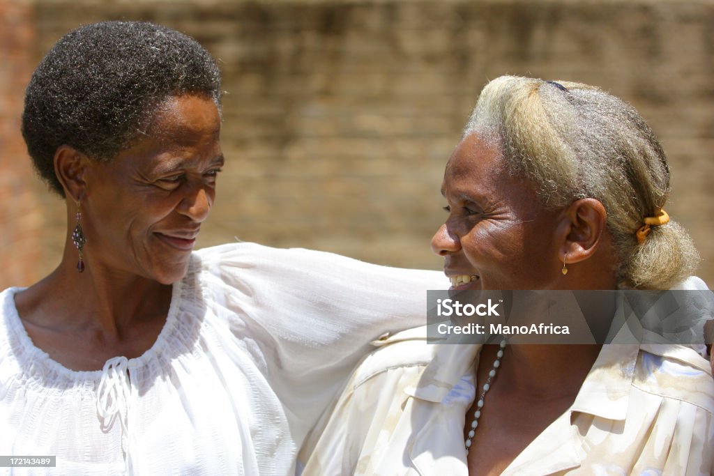 African Mother and Daughter two An ethnic mature daughter and old mother express their love for one another. Active Seniors Stock Photo