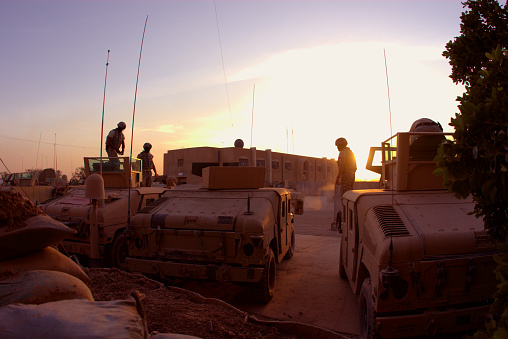 View of Soldiers and Armored HMMWV (Humvees) in Ramadi, Iraq. They are getting ready for patrol.