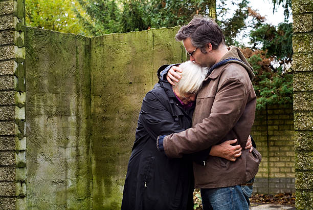 Son consoling his mother stock photo