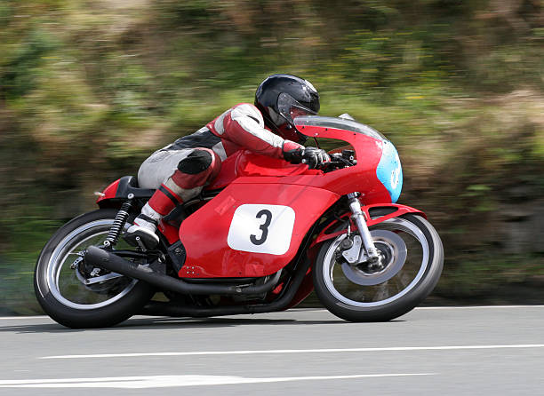 A racer on a red motorcycle with matching gear on the road A classic Rider at speed in at the Manx Grand Prix Road Race. motorcycle racing stock pictures, royalty-free photos & images