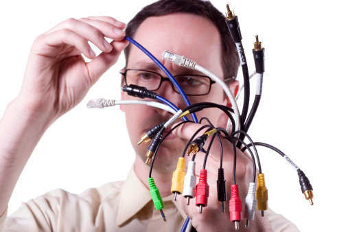 Guy examines collection of audio and video cables.