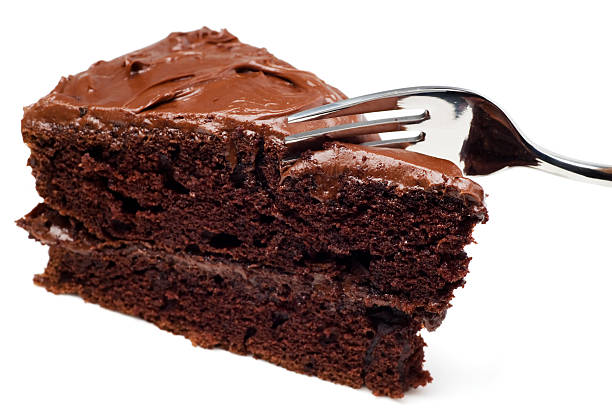 Fork cutting into a slice of chocolate cake.  Isolated on White.