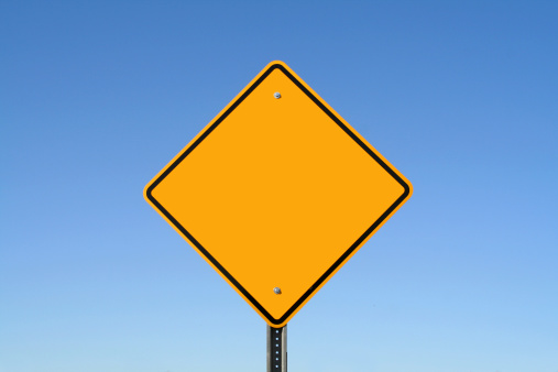 A blank yellow sign against a perfectly clear blue sky
