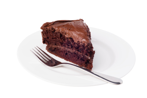 A delicious slice of chocolate cake with chocolate frosting.  Isolated on white with clipping path.