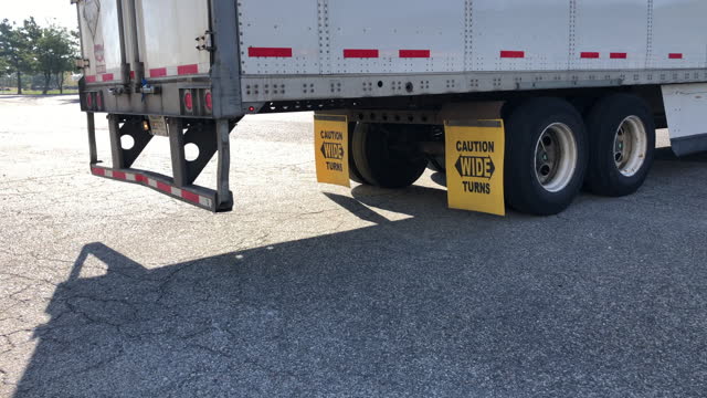 Truck with mud flaps that say, CAUTION WIDE TURNS