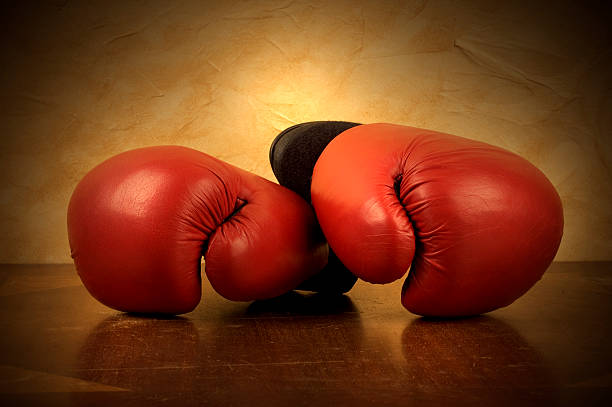 istock A pair of red boxing gloves on. Reflective brown surface 172147184