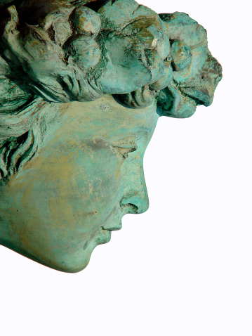 Close up of copper (bronze) statue of woman's head looking down. Isolated on white background.