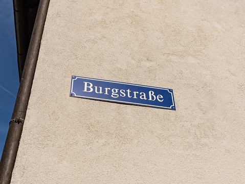 Burgstraße street name sign on a building exterior. The road signage is on a facade and gives information about the location.