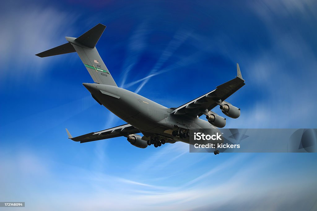 A military cargo plane flying in the blue sky A C17 Globemaster 3 just about to touch down. Rear View Stock Photo