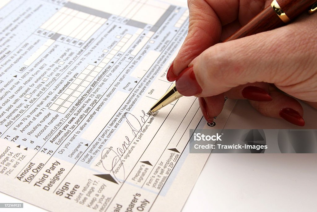 Jane Doe Signature Ms. Jane Doe signs her tax form 1040 Refund Stock Photo