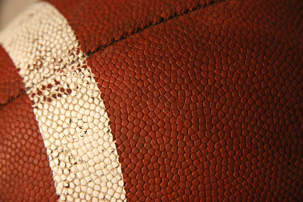 Football -01 This is a close up picture of a football. The picture was taken at sunset to give the football a very soft warm glow. It brings out the feeling of post game emotions. At 100% you can see all the small scratches and things on the surface of the football.    american football ball stock pictures, royalty-free photos & images