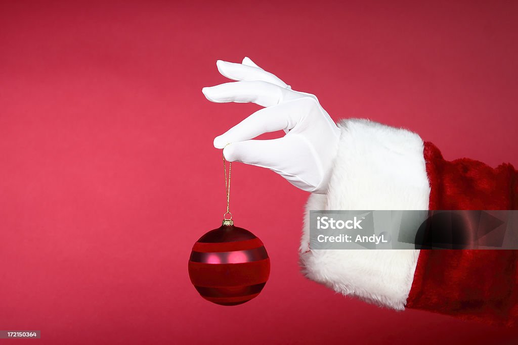 Santa руки: Держит красный Ornament - Стоковые фото Белый роялти-фри