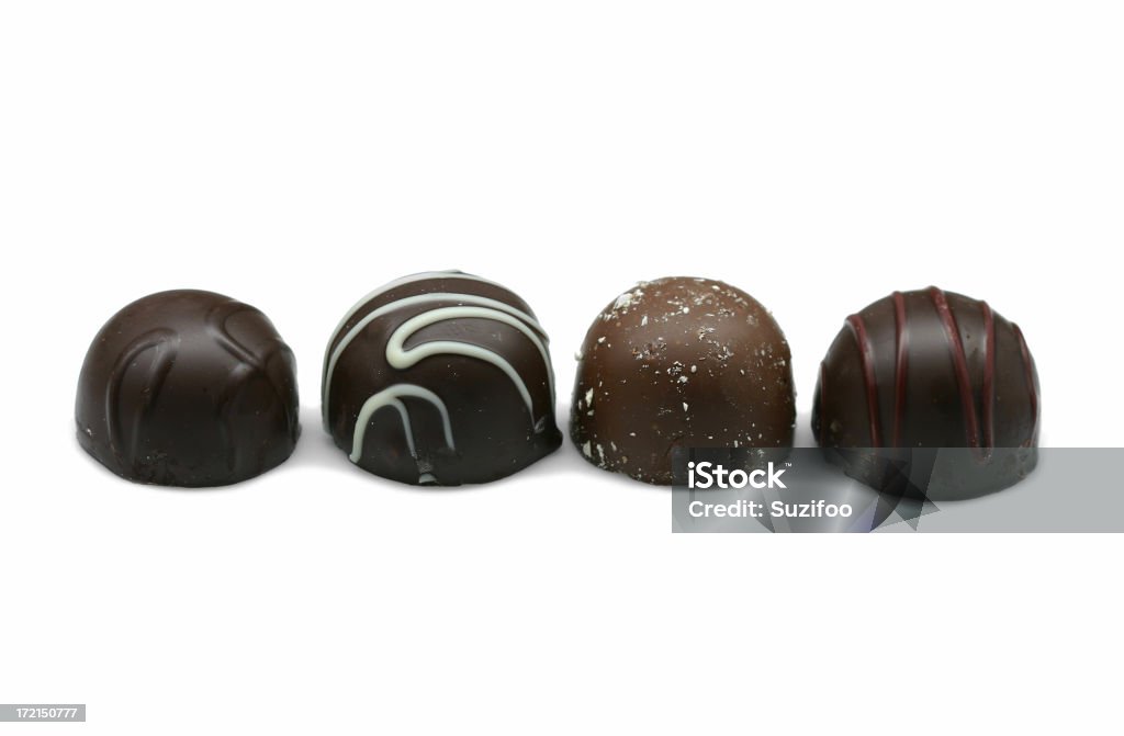 chocolate truffles "A lineup of four chocolate truffles:  dark chocolate, raspberry, almond, and cherry. Shallow depth of field. Isolated on white." Almond Stock Photo