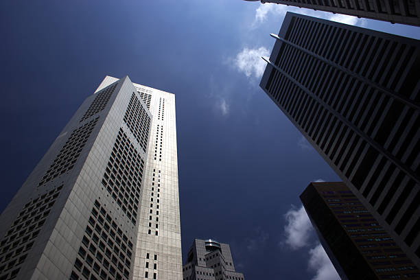 Modern skyscrapers in business district with blue sky and clouds background. In front palm trees.