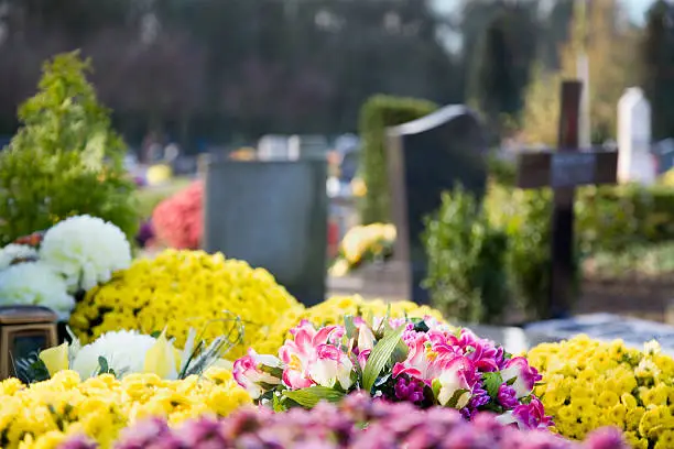 Flowers on the graves, with tombstones in the background.