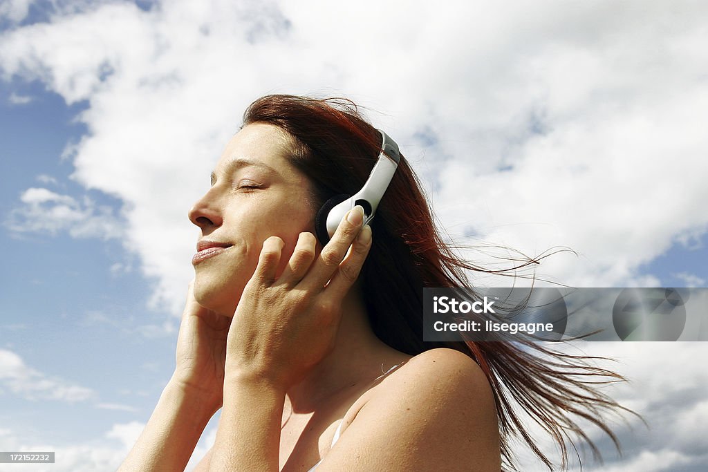 Kobieta słuchania muzyki na zewnątrz - Zbiór zdjęć royalty-free (Chmura)