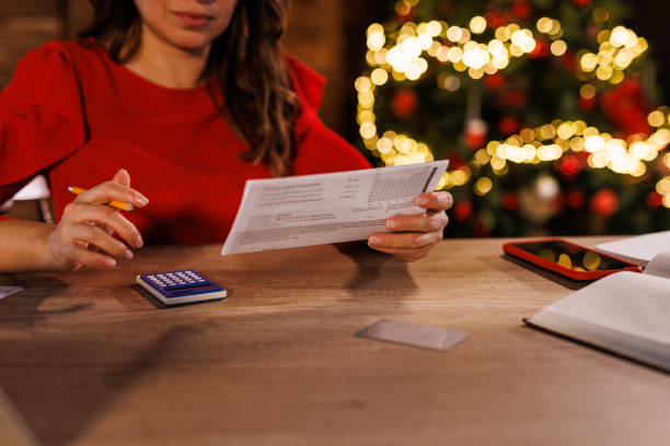 Woman doing finances at home office desk during Christmas holidays stock photo