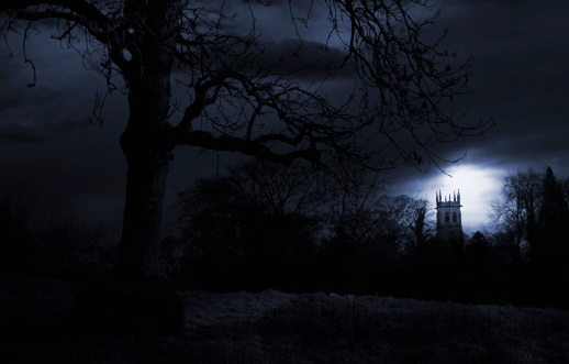 An eerie landscape with a church spire rising behind the trees. Has film grain at full size.
