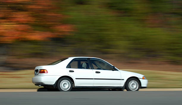 istock Economy Car Speeds Past Fall Trees 172153390