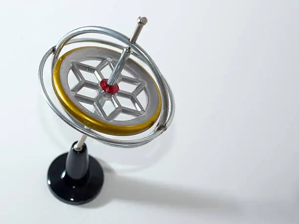 A spinning gyroscope on a black stand. The motion is froozen by the flash and shutter speed.