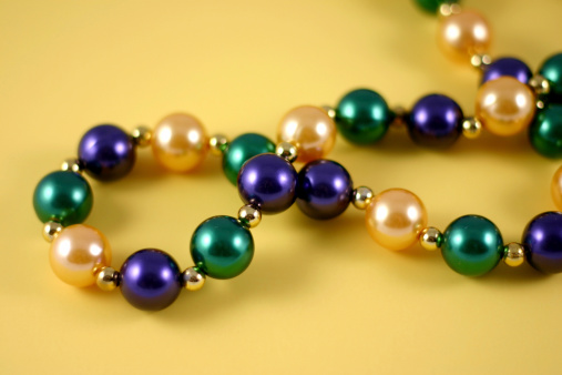 mardi gras beads on yellow background.