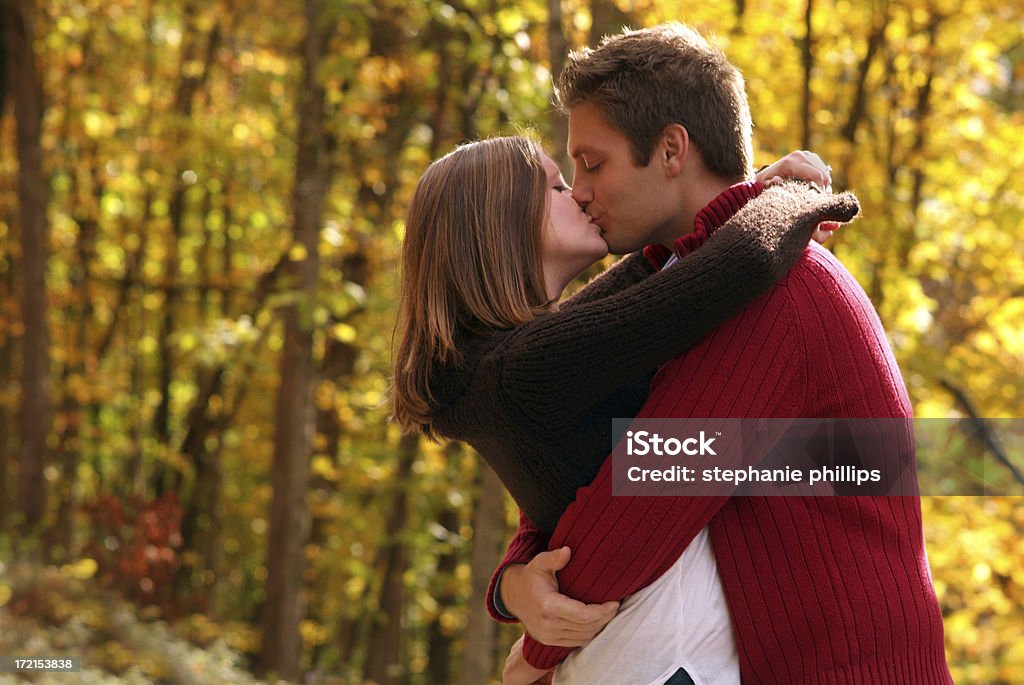 Giovane coppia adulta bacio in autunno all'aperto - Foto stock royalty-free di 20-24 anni