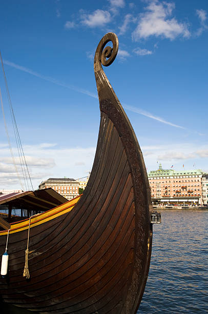 Stylized wooden boat of Vikings with shields on the sides on the Daugava river in Riga