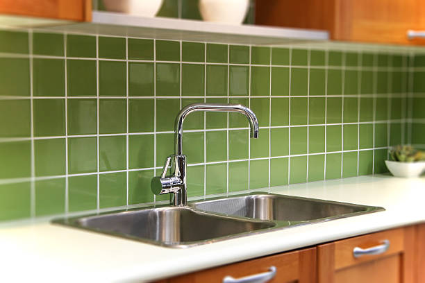 Clearing food scraps on dish to trash before clean in sink.