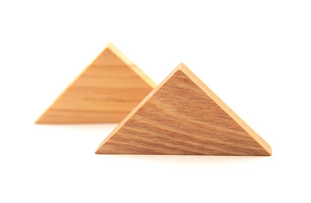 Two Wood Triangles "Shallow DOF; the closest triangle is crispy in focus, the rear one is not.  Some soft shadow detail preserved in isolation, but every pixel is pure white at the absolute edges of the image." isosceles triangle stock pictures, royalty-free photos & images