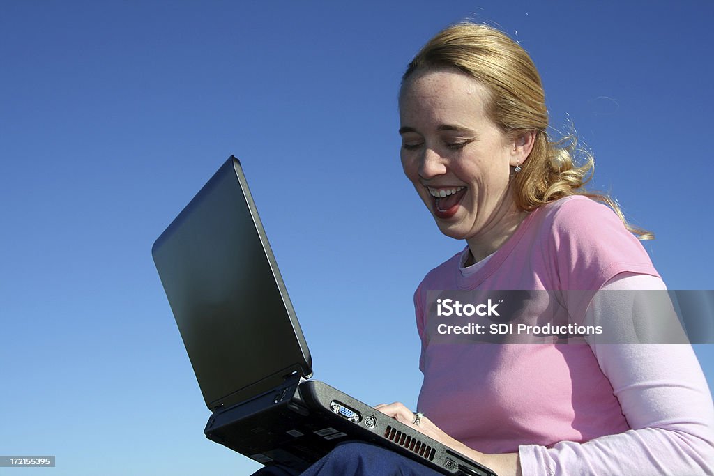 Mujer feliz trabajando en su computadora portátil al aire libre - Foto de stock de Actividad libre de derechos