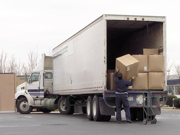 Unloading the Truck Man off loads boxes from an 18 wheeler unloading photos stock pictures, royalty-free photos & images