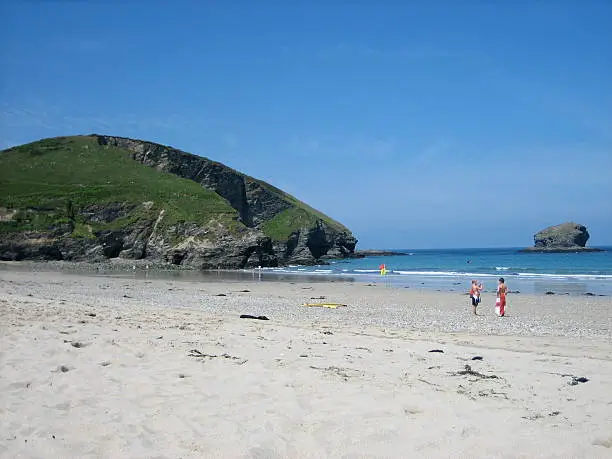"Perranporth Beach, Cornwall under a deep blue sky. Foreground shows 2 boys - one wrapped in an England Flag towel."