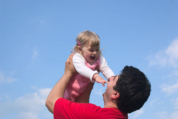istock Happy child in father hands up against serene sky 172156222