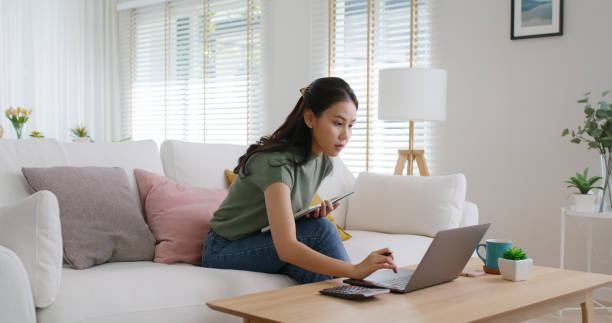 istock Reskill upskill for young adult talent workforce remote work at home hybrid workplace. Asia woman happy smile sit at sofa couch learn online study MBA video call share plan idea write note on tablet. 1721563364