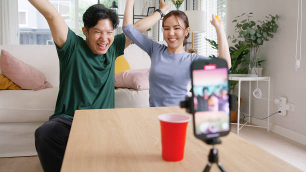 Adult influencer youtuber asia people vlogger record viral video vlog page live fun game beer ping pong ball throw cup on IG reel instagram tiktok social media trendy joy side hustle for young couple. influencer adulto youtuber asia gente vlogger grabar video viral página de vlog juego divertido en vivo cerveza ping pong pelota lanzar taza en el carrete de ig instagram tiktok redes sociales alegría de moda ajetreo secundario para pareja joven.