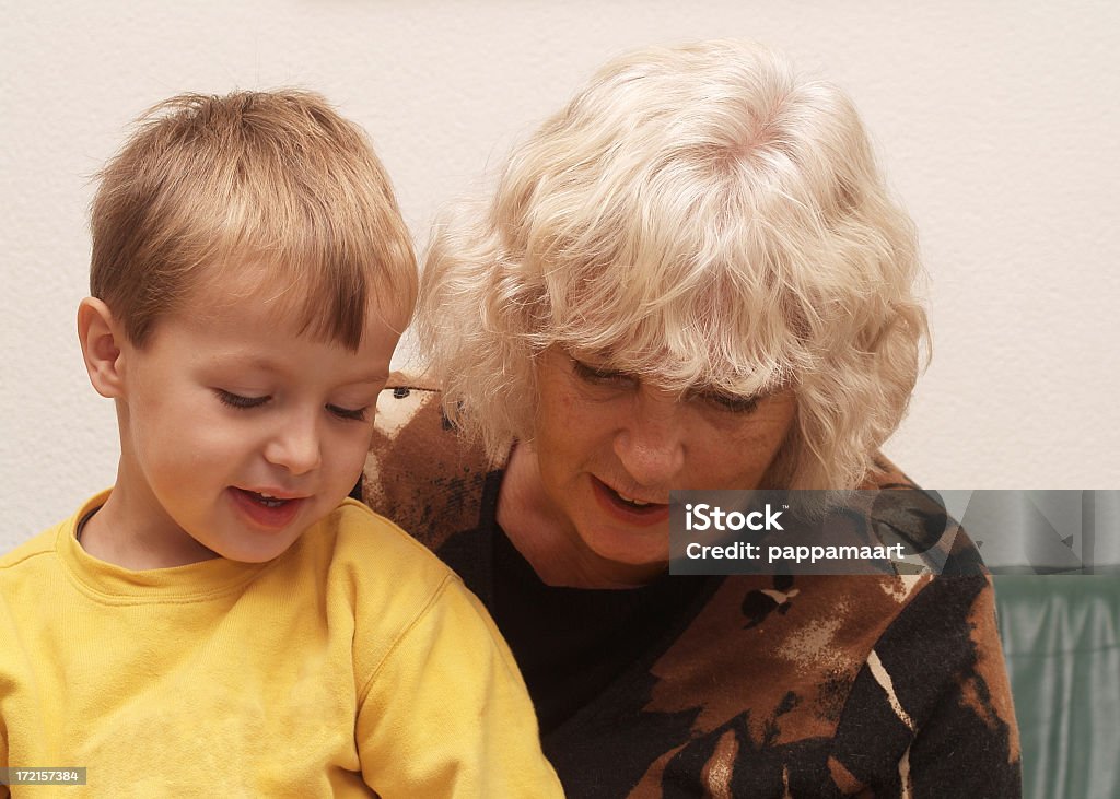 Grandmother and grandchild 2 Senior woman interested in her grandson sitting on her lap. 2-3 Years Stock Photo