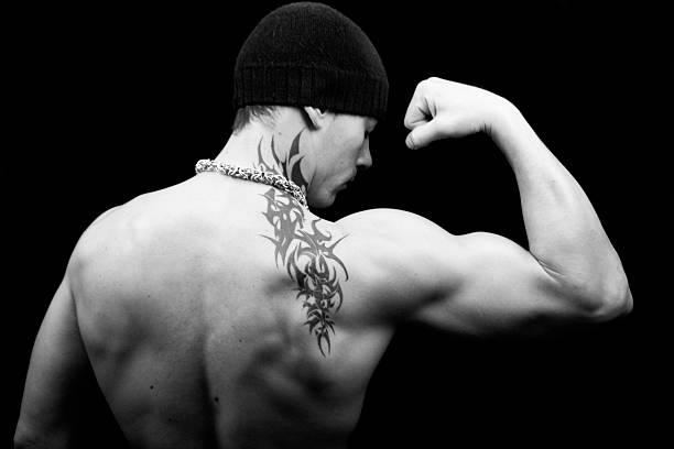 Flexing Young tattooed guy flexing his arm yt stock pictures, royalty-free photos & images