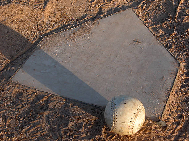 softball ruhen auf home plate - baseball dirt softball baseball diamond stock-fotos und bilder